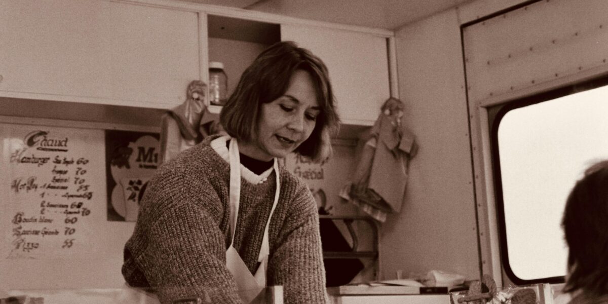 Woman preparing meals in a kitchen with containers and ingredients for weekly meal prep