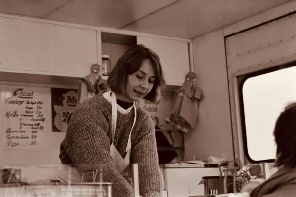 Woman preparing meals in a kitchen with containers and ingredients for weekly meal prep