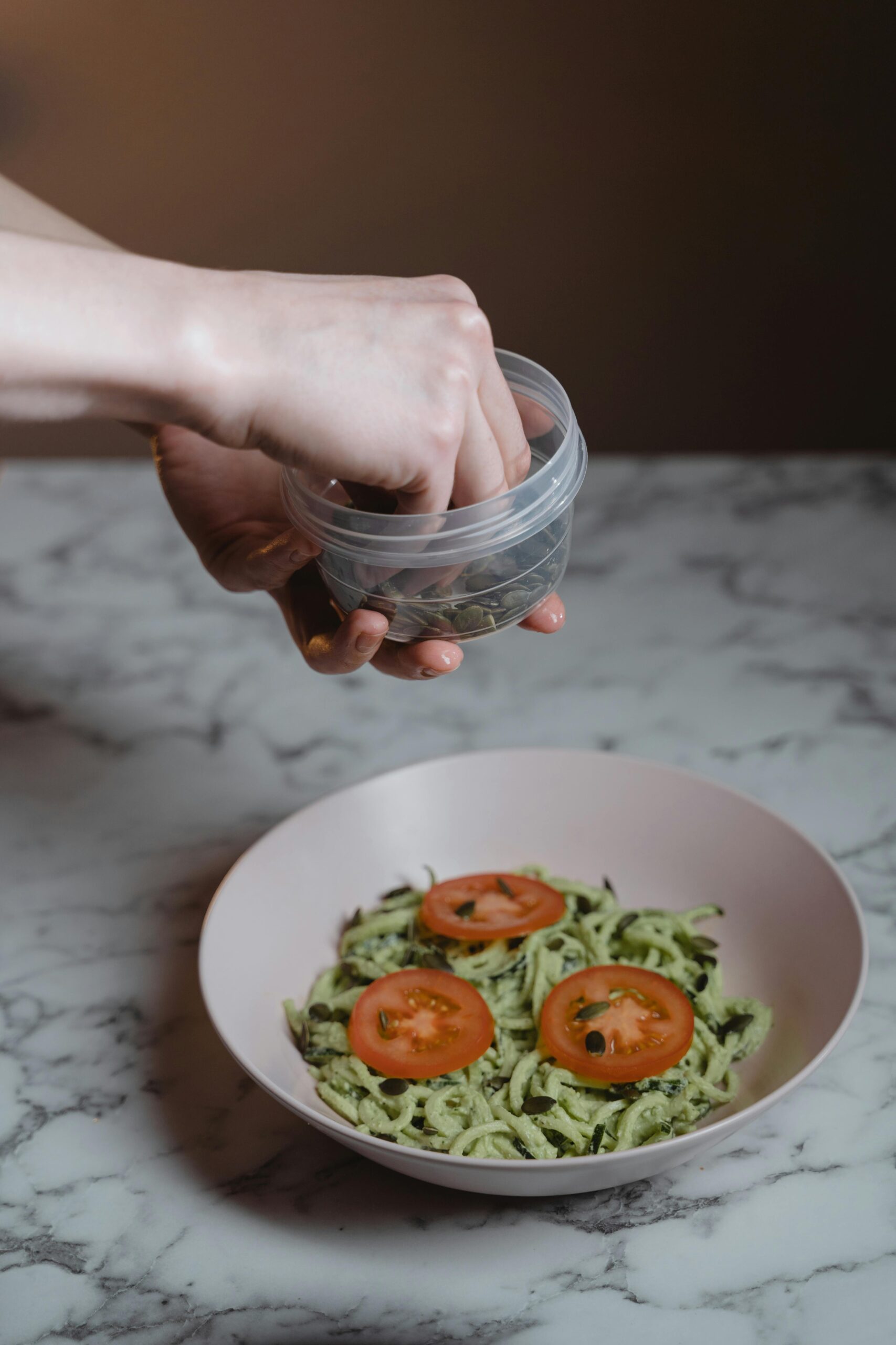 Person holding and using a plastic food container while preparing a healthy meal